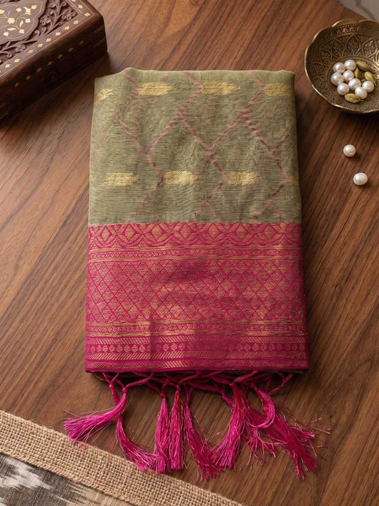 Green and pink patterned fabric with tassels on a wooden surface