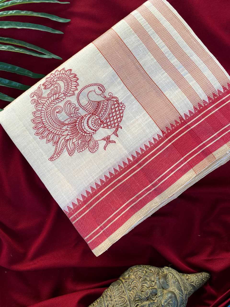 Red and white saree with intricate design on a red fabric background
