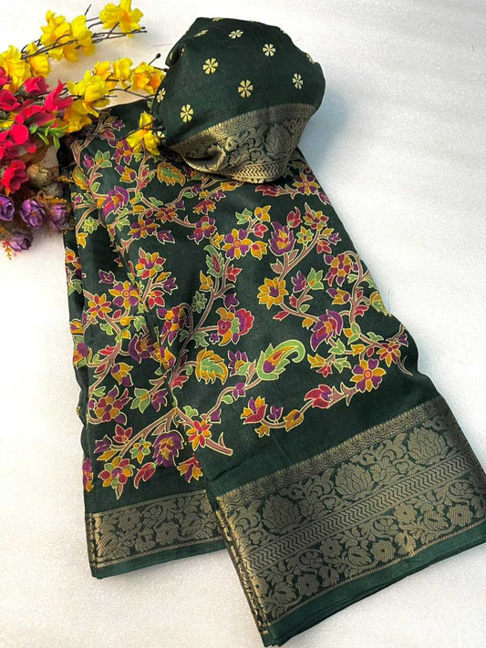 A dark green floral printed fabric set with a matching head covering, laid flat on a white background with decorative yellow and red flowers in the top left corner. The fabric features a multicolor floral pattern with yellow, pink, and green blossoms on a dark green base, finished with a wide metallic gold brocade border.