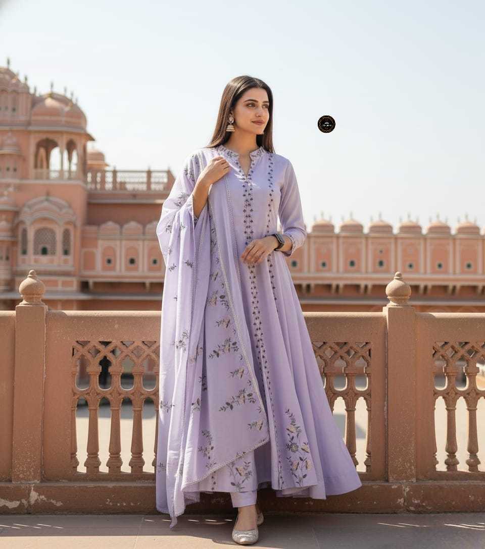 Woman in a light purple traditional outfit standing in front of a historic building.