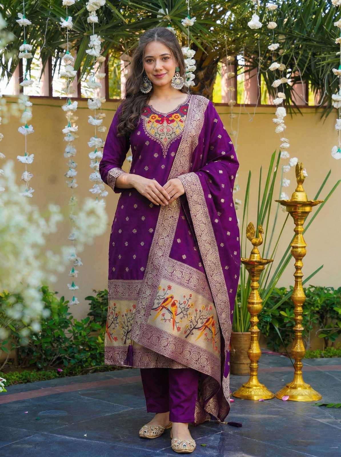 Woman in a purple traditional outfit with floral decorations in an outdoor setting.