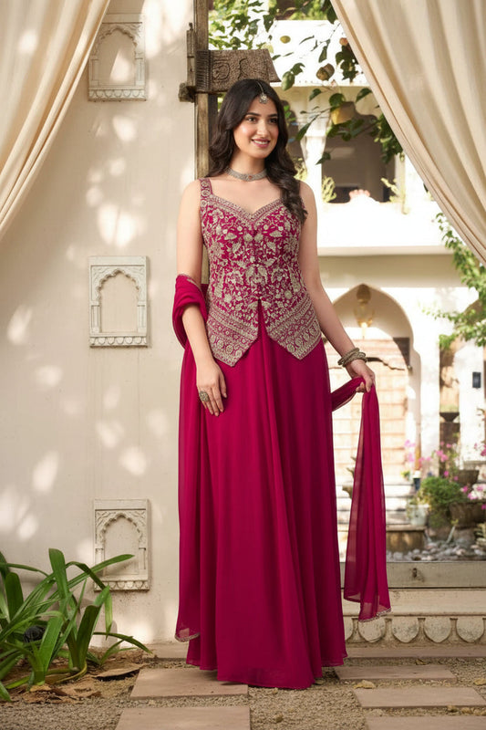 A woman modeling a deep magenta pink georgette maxi dress with heavy gold embroidery on the bodice and a matching dupatta, shown against an outdoor stone walkway. The image includes a fabric details inset on the left and size text overlays on the right.