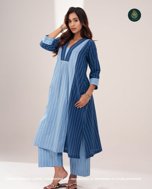 A woman modeling a dual-tone indigo cotton co-ord set with a sleeveless inner kurta and a flowy open-front jacket, paired with matching straight-fit pants.