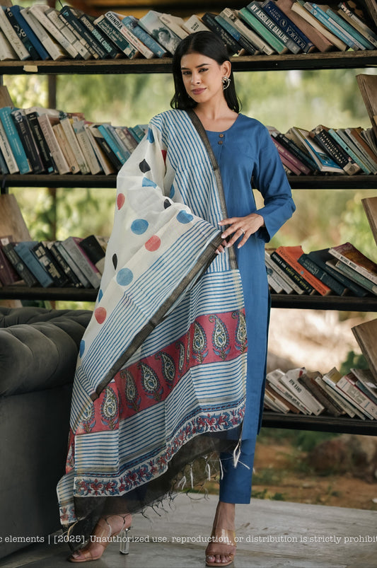 Woman holding a patterned fabric in front of a bookshelf