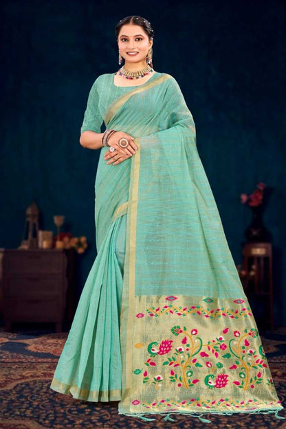 Woman wearing a light blue saree with floral patterns on a dark background