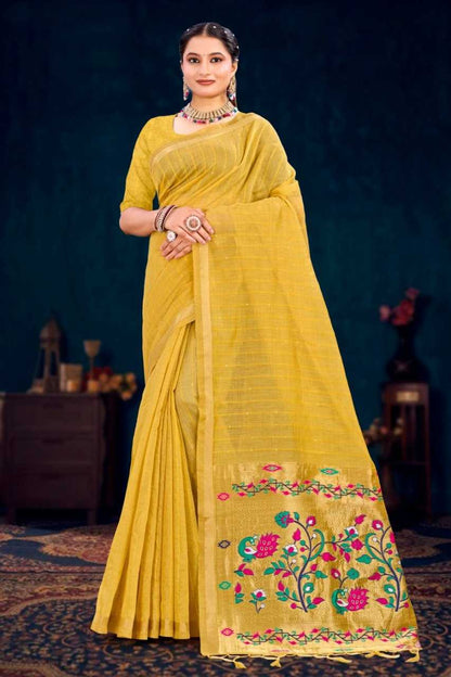 Woman wearing a yellow saree with floral embroidery against a dark background
