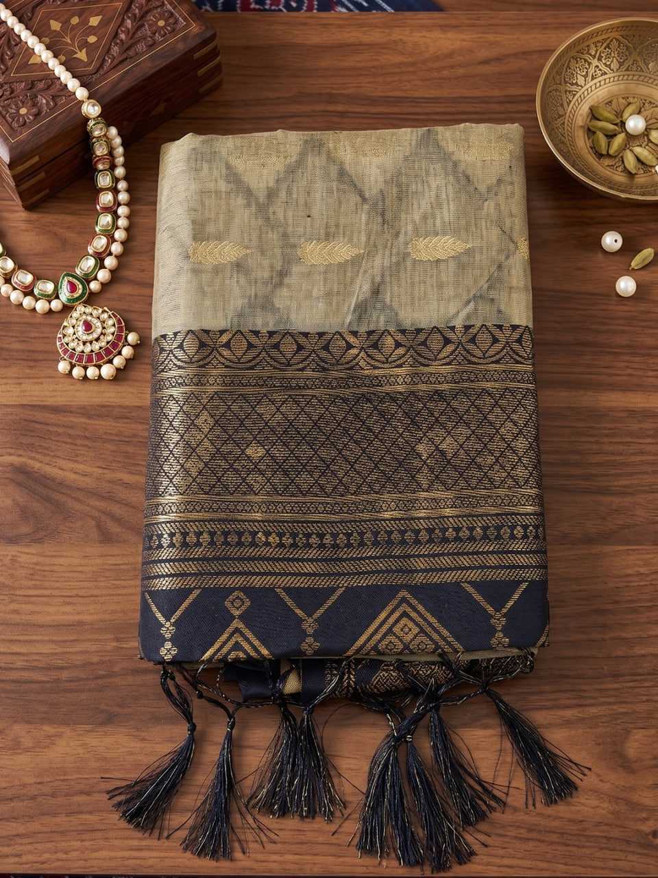 Textile with intricate patterns and tassels on a wooden surface