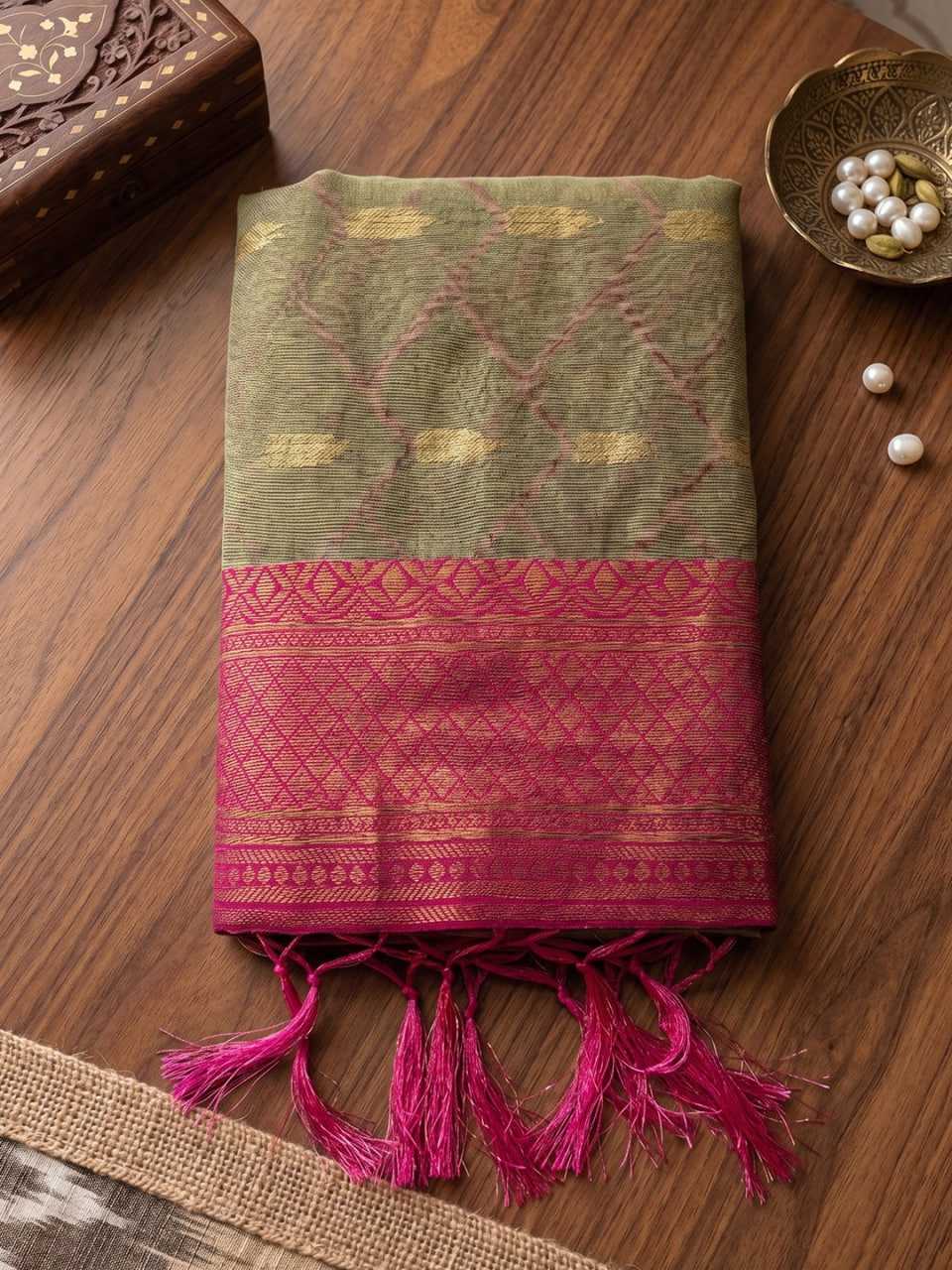 Green and pink patterned fabric with tassels on a wooden surface