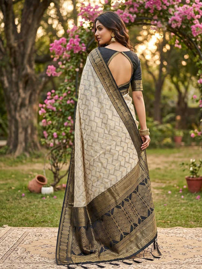 Woman in a traditional saree standing in a garden with pink flowers and greenery.
