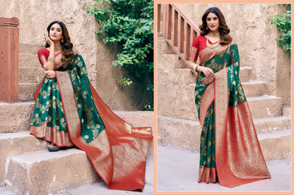 Woman in a green and red saree with gold patterns, standing on steps with greenery in the background. Brand 'Gobuni' visible.