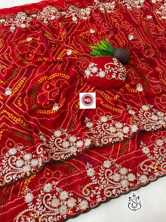 Red embroidered fabric with intricate patterns on a white background