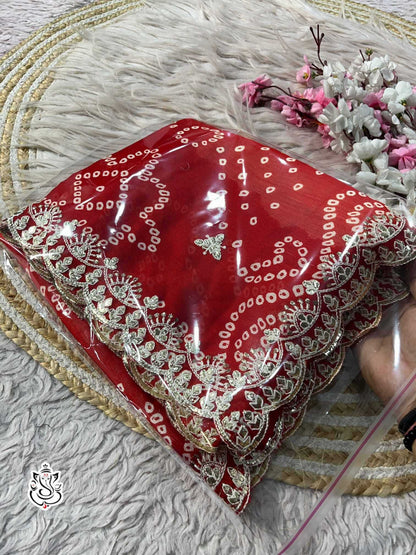 Red embroidered fabric on a textured surface with flowers