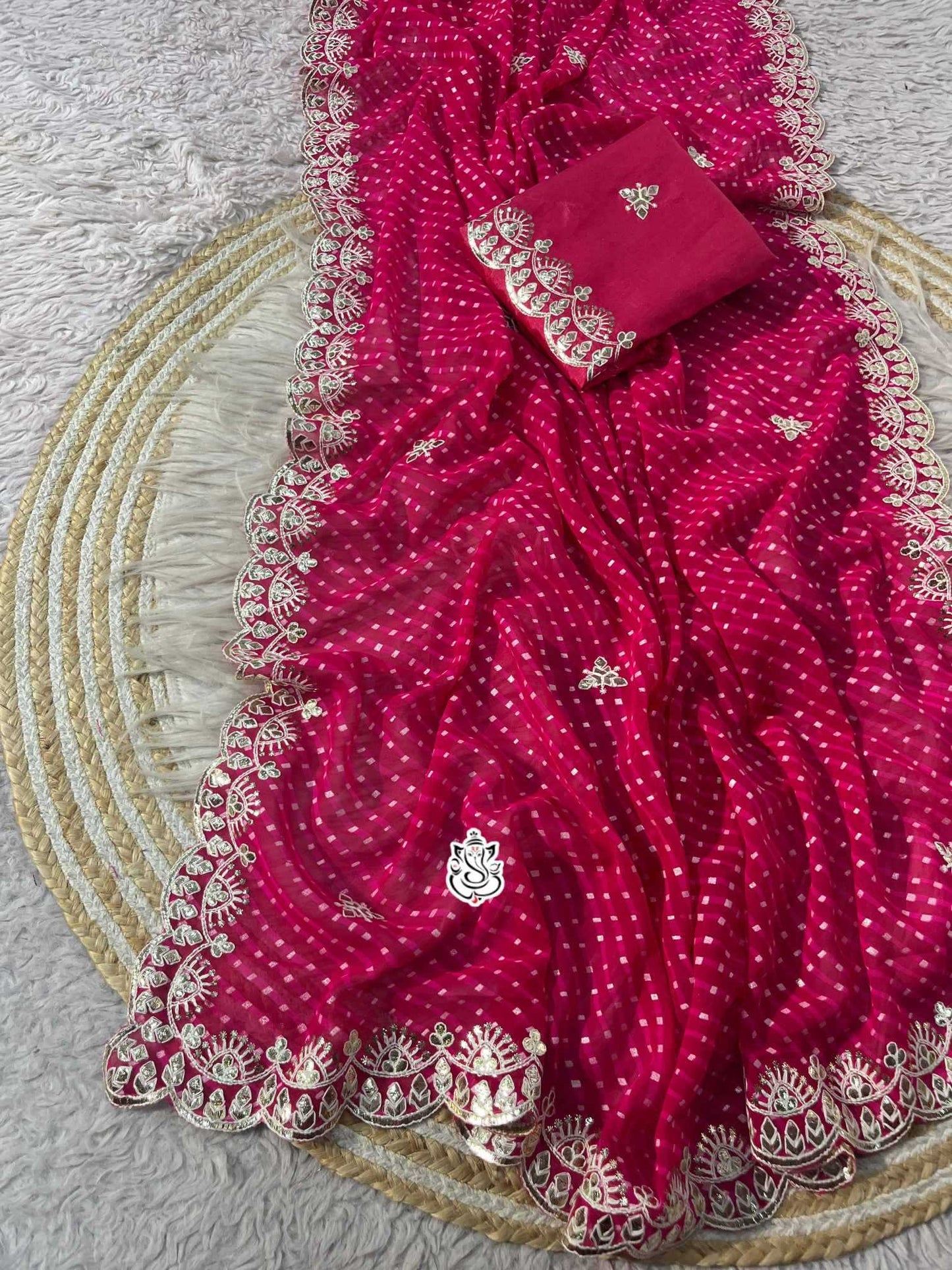 Red saree with white patterns on a textured surface