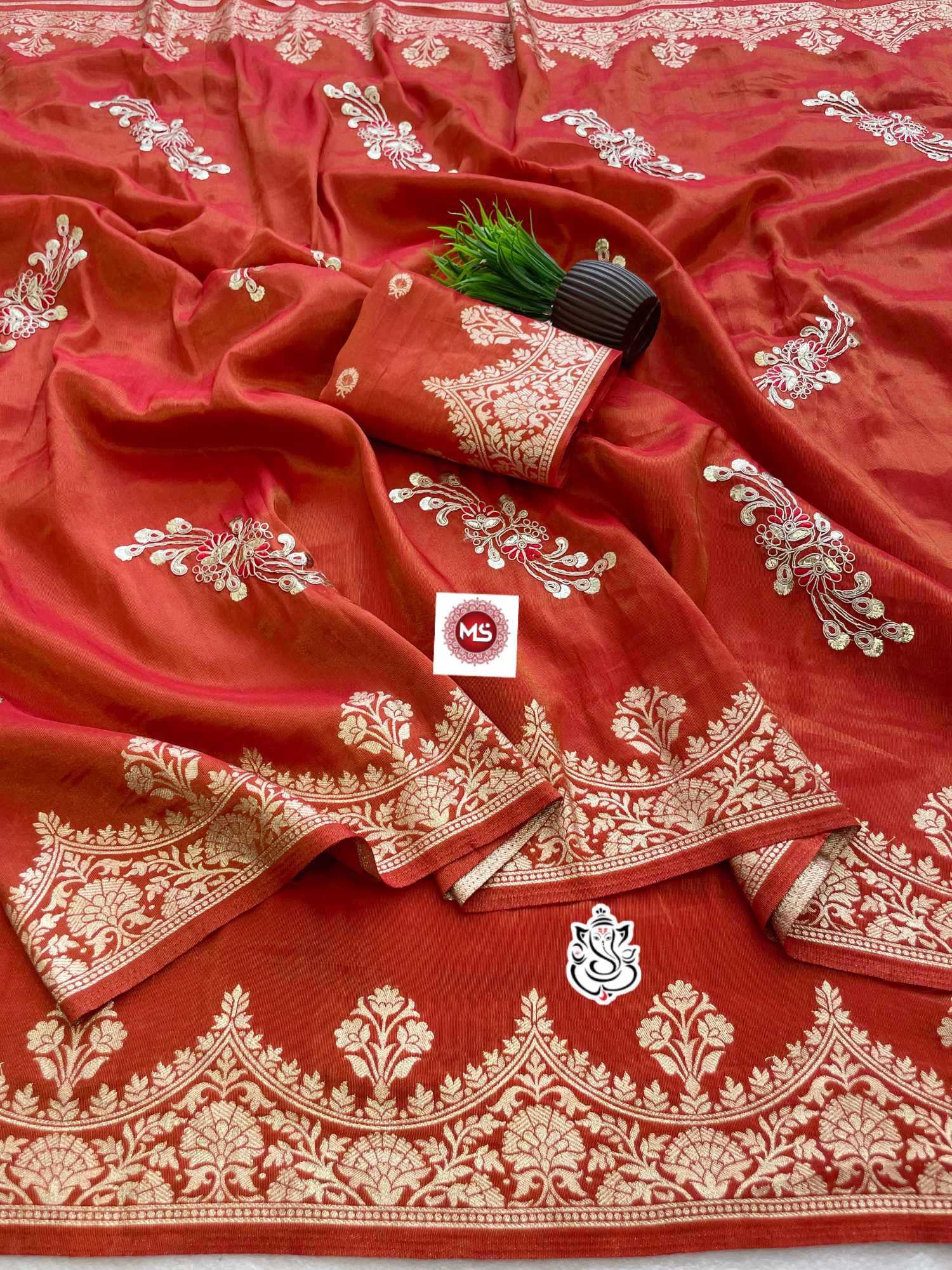 Red fabric with white embroidery and a visible brand logo on a white background