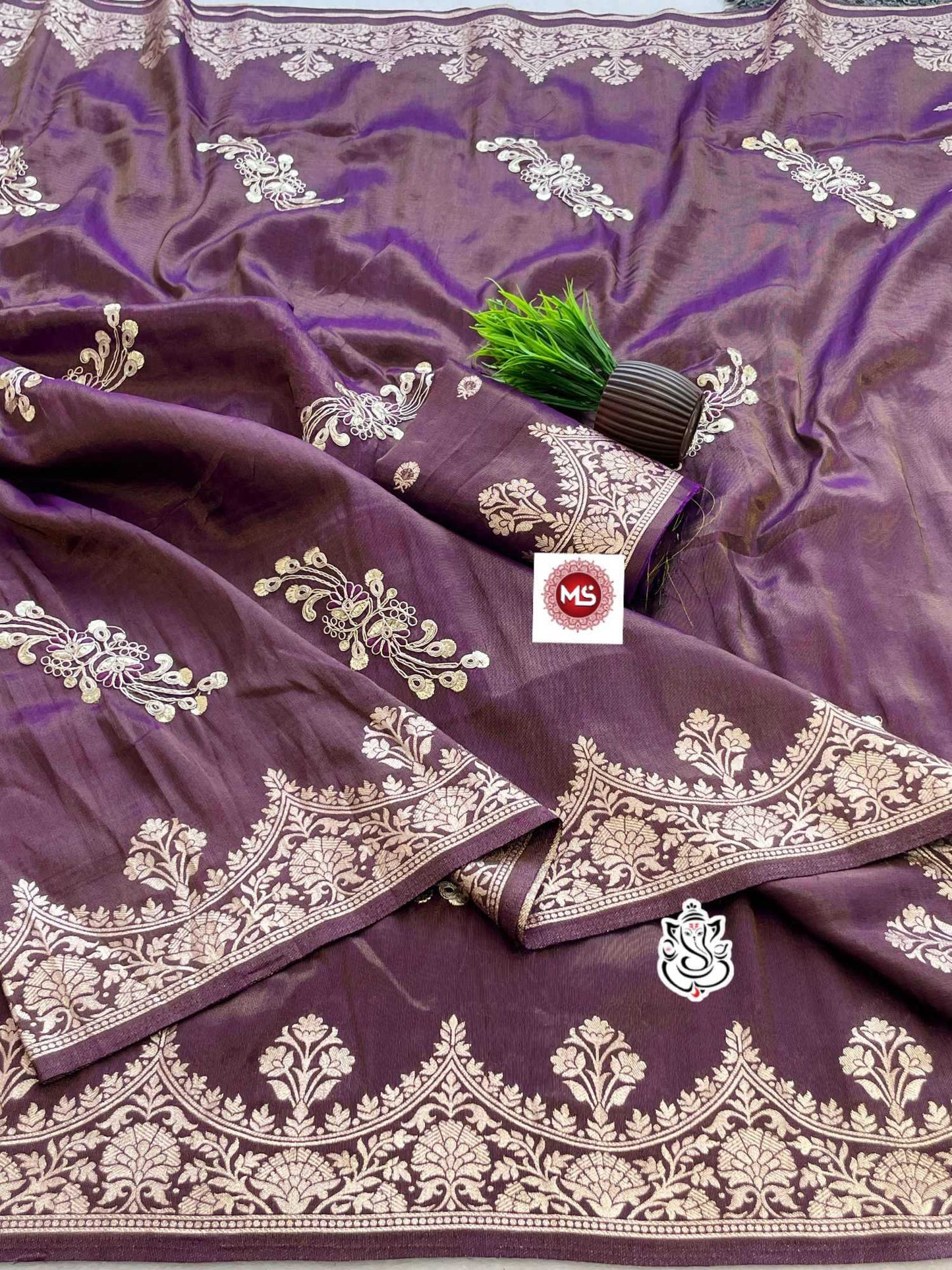 Purple fabric with gold embroidery and a brand logo in the center.