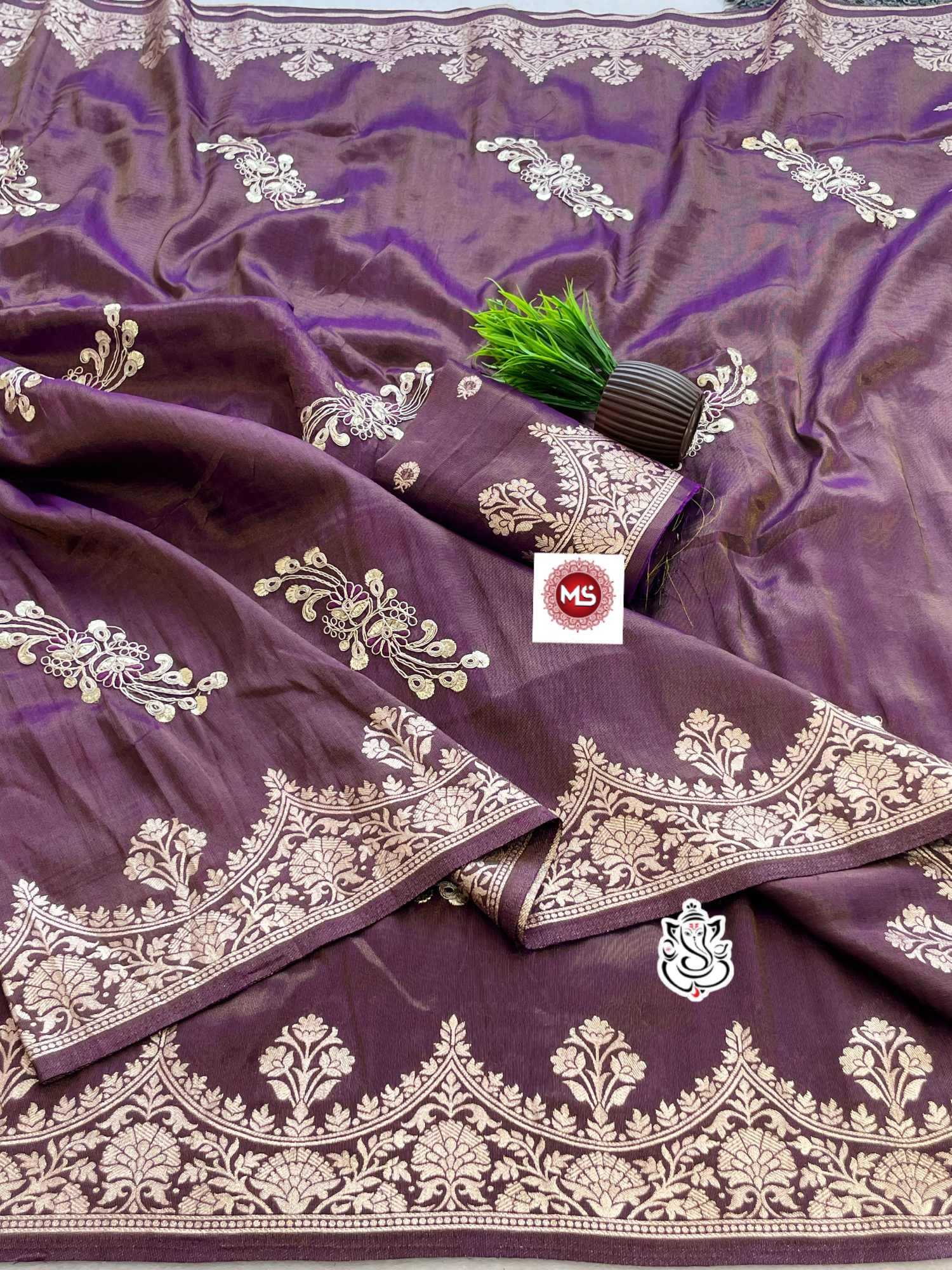 Purple fabric with gold embroidery and a brand logo in the center.