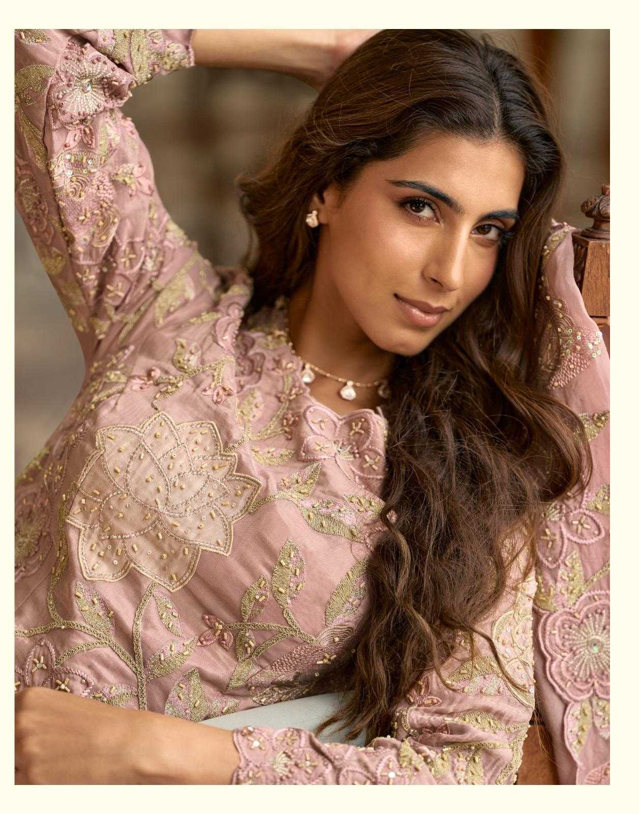 Woman wearing a pink embroidered traditional outfit with a blurred background