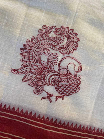 Embroidered design of a rooster on a fabric with red thread.
