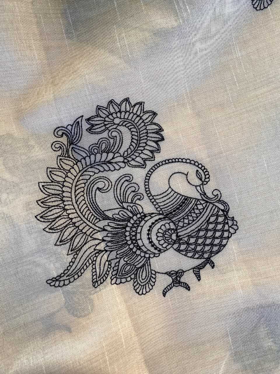 Decorative black peacock design on beige fabric