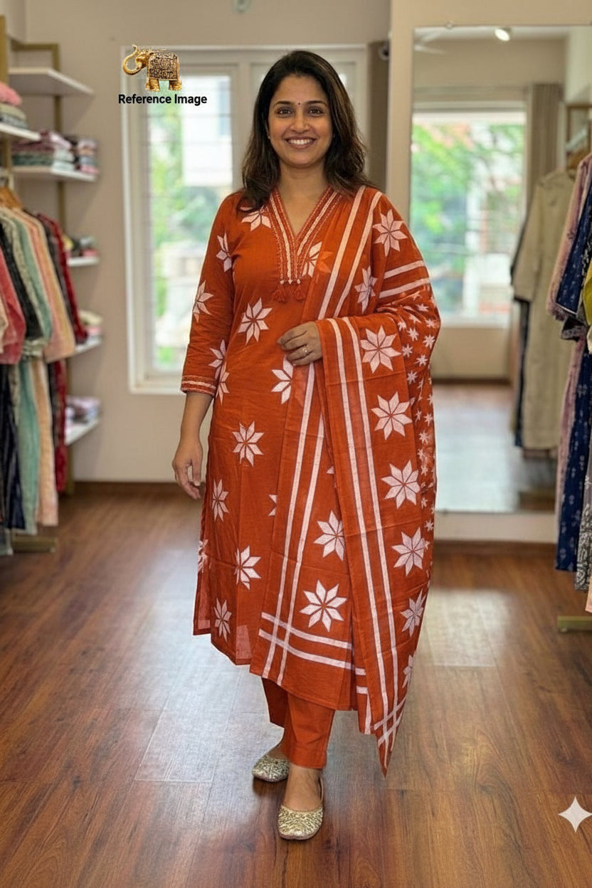 Woman wearing an orange and white traditional outfit in a clothing store.