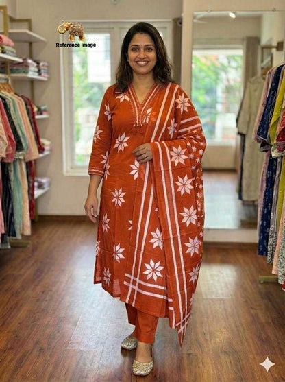 Woman wearing an orange and white traditional outfit in a clothing store.