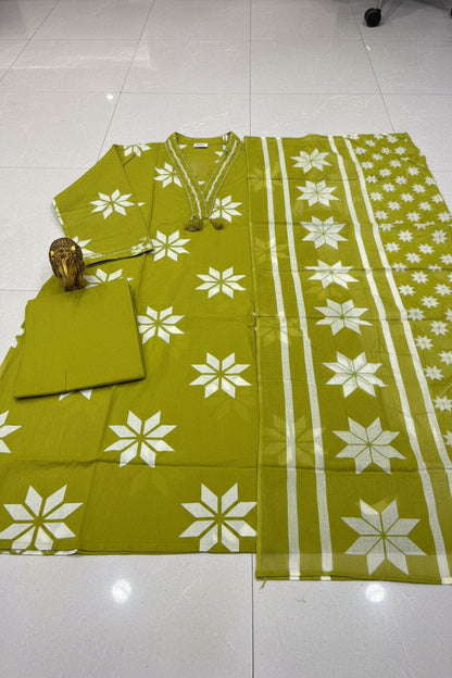 Green and white floral patterned fabric on a table with a person holding it.