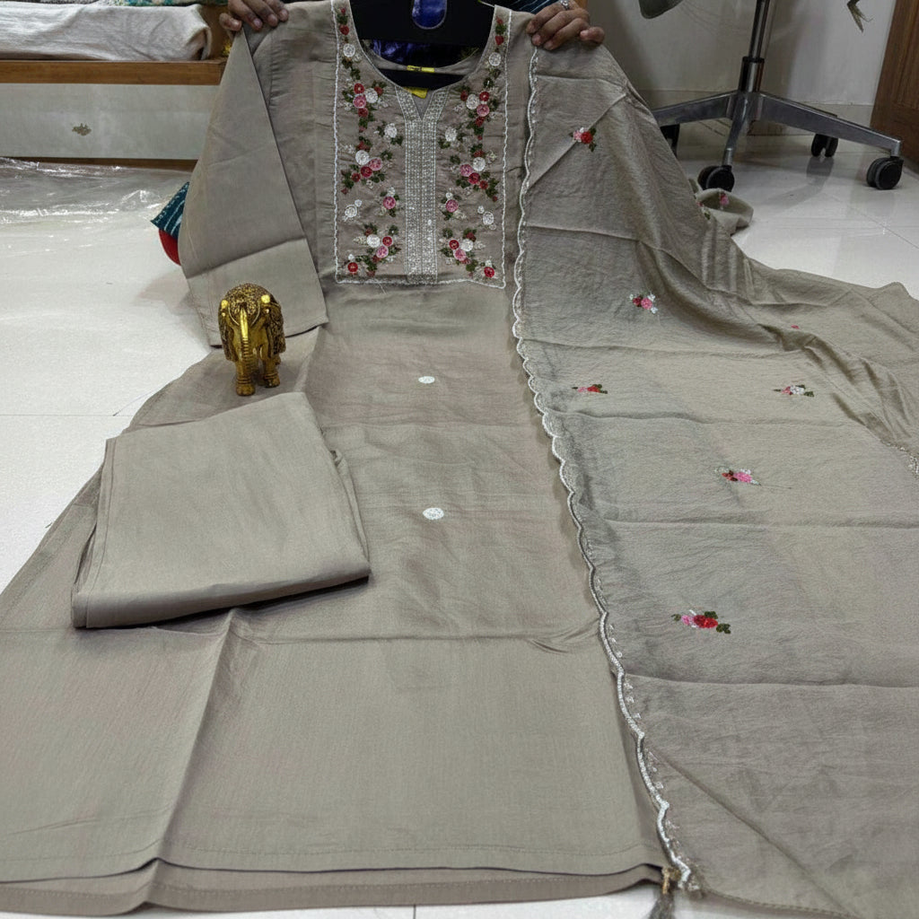 Gray traditional outfit with floral embroidery on a white floor.