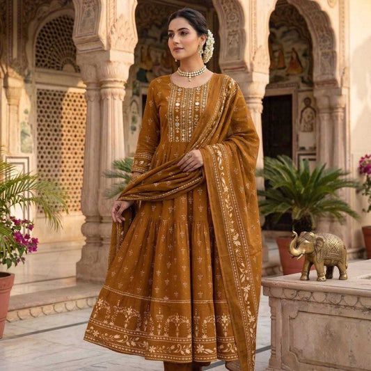 Woman in a mustard yellow traditional outfit standing in an ornate courtyard.