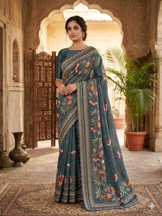 Woman in a traditional saree standing in an ornate indoor setting with plants.