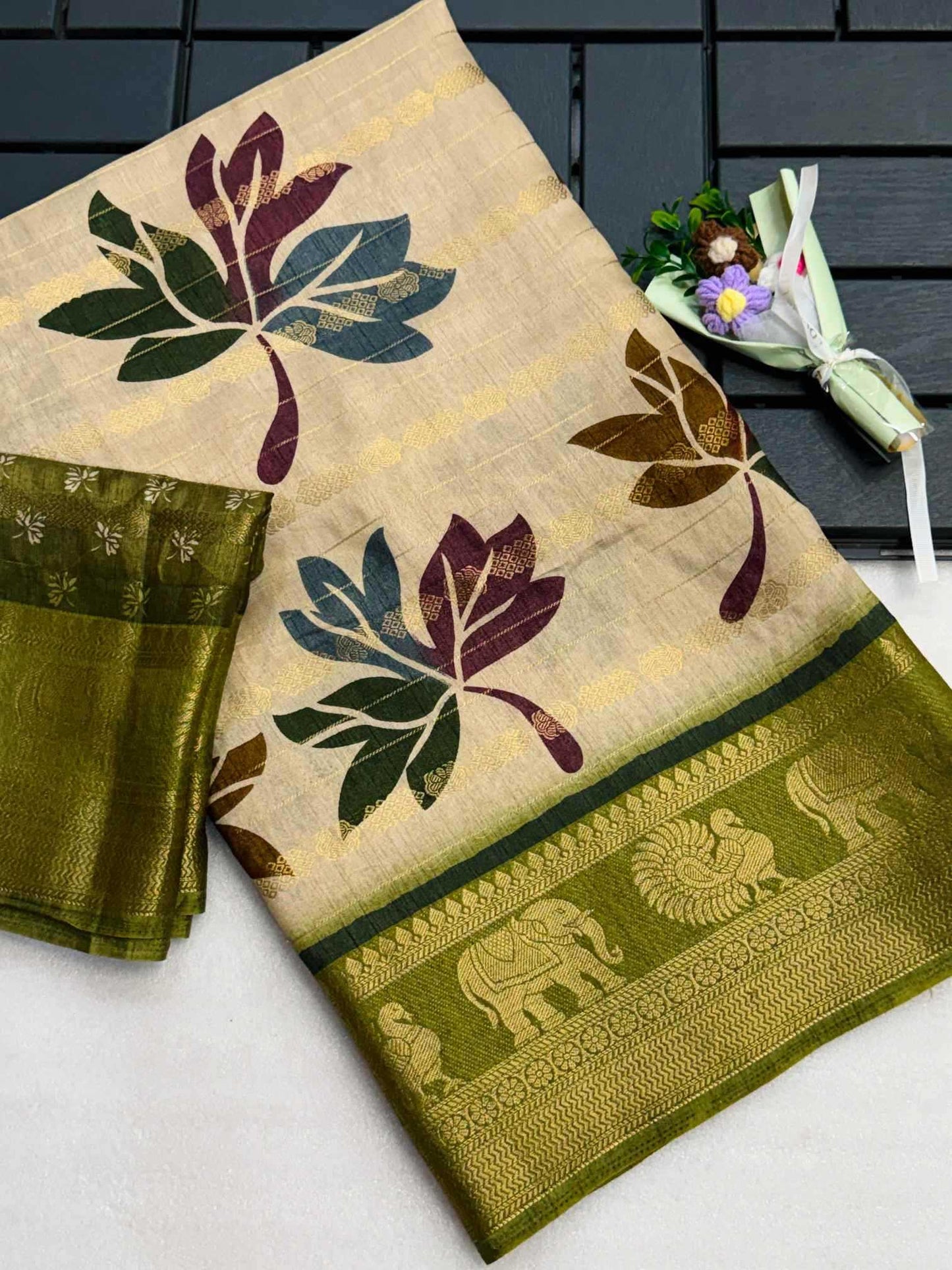 Traditional saree with leaf patterns and elephant design on a white background