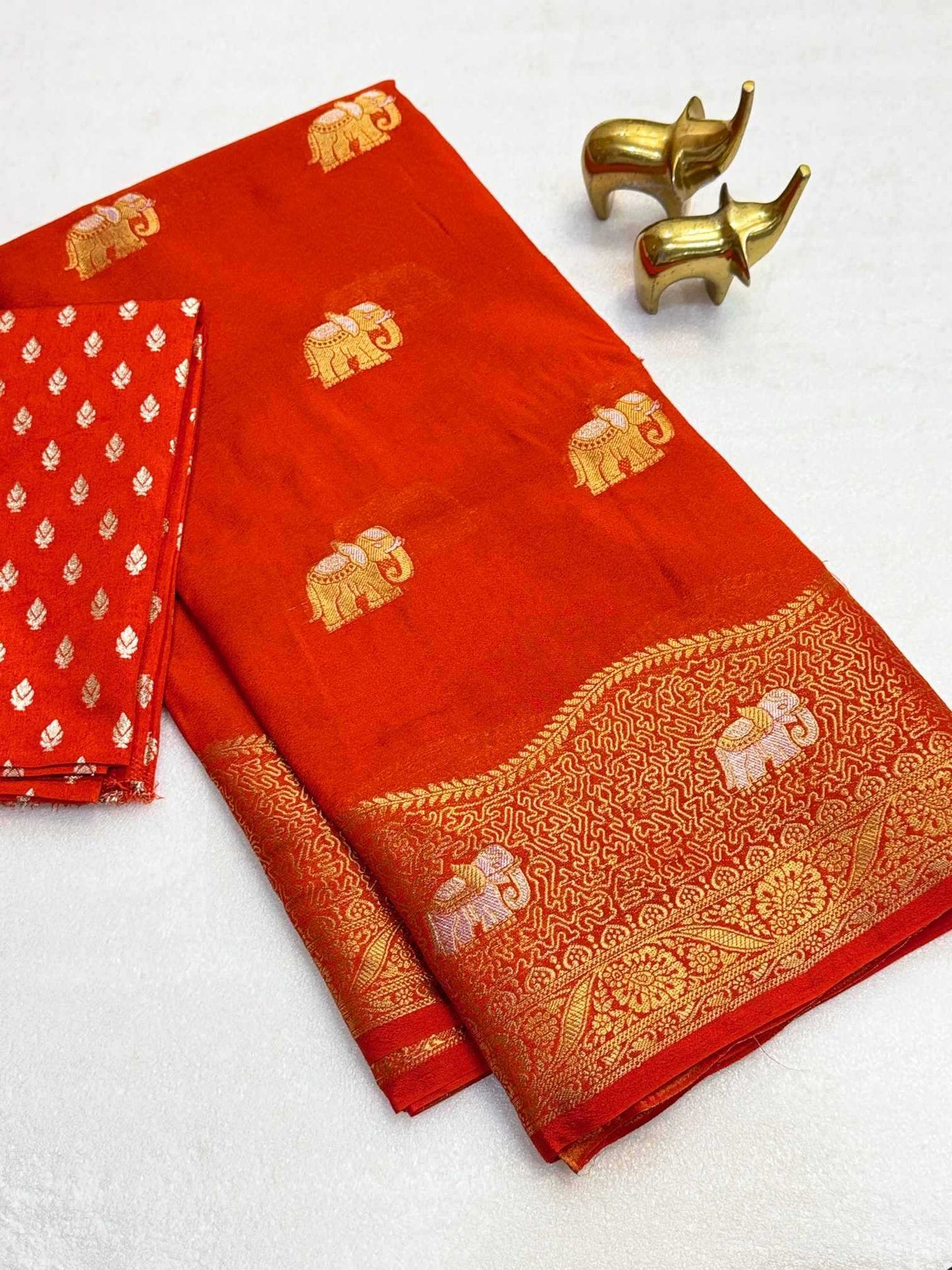 Red saree with gold elephant patterns on a white background