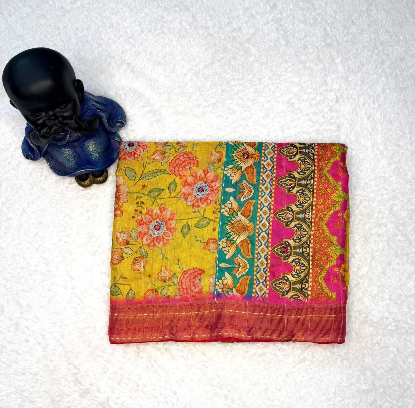 Colorful patterned fabric with a small black statue on a white background