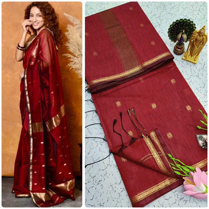 Red saree with gold border worn by a model and laid flat on a textured surface.