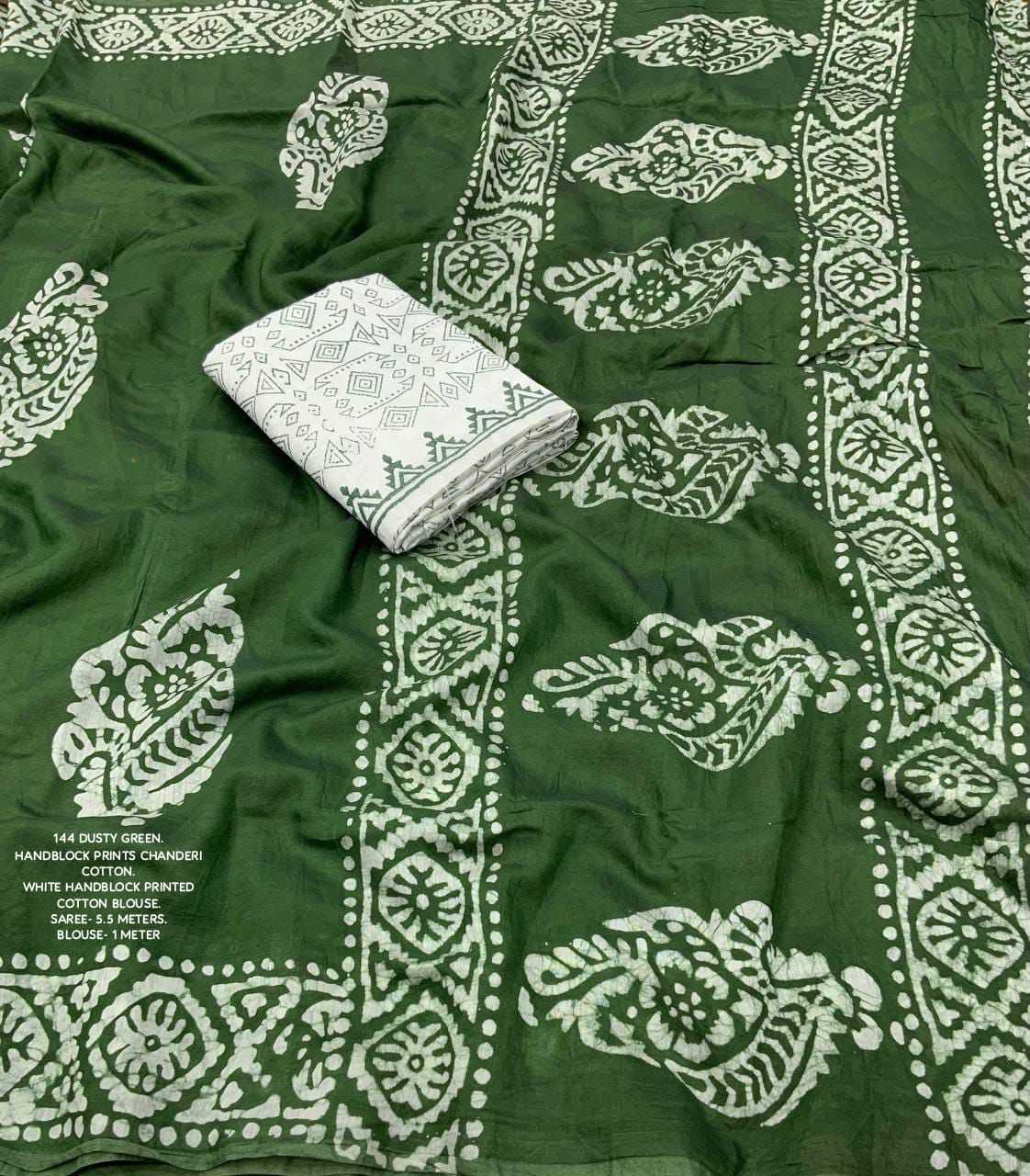 Green fabric with white pattern and a folded white cloth on top