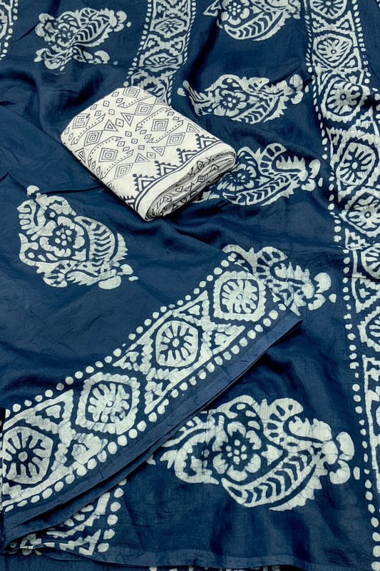 Blue fabric with white handblock prints and a folded piece of fabric on top.