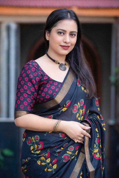 Woman wearing a dark blue saree with floral patterns in an outdoor setting