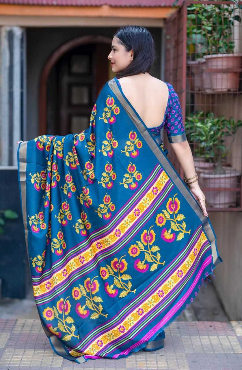 Woman wearing a blue saree with floral patterns in an outdoor setting