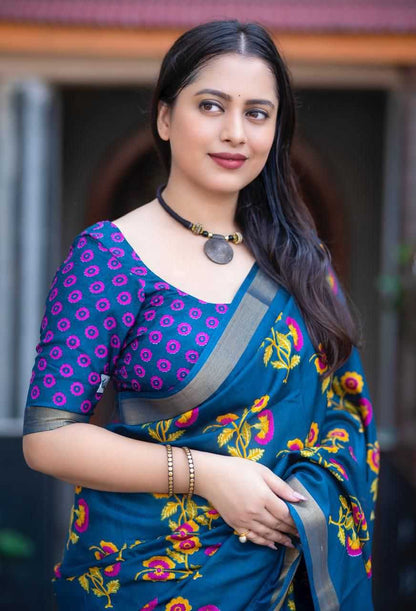 Woman wearing a blue saree with floral patterns in an outdoor setting