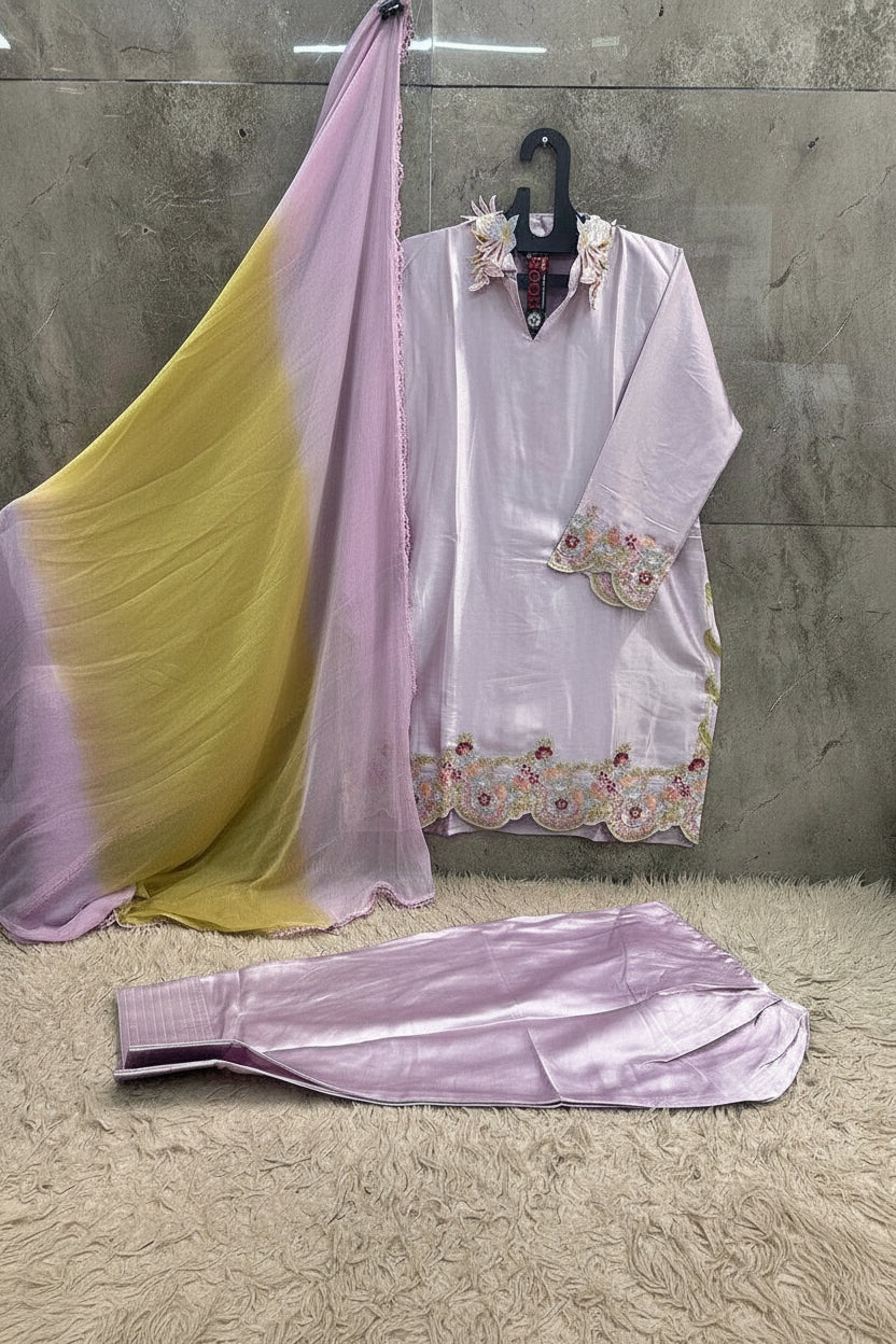 A light pink traditional outfit set with a matching dupatta draped over a hanger, and matching pants laid out in front. The outfit has floral embroidery on the neckline and sleeve cuffs, and scalloped floral border detailing on the hem.