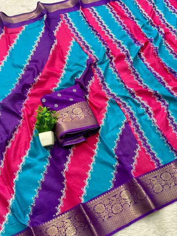 A folded and draped silk saree with diagonal stripes of turquoise, magenta pink, and purple, featuring a wide gold brocade border and a matching fabric piece with a small green plant accent.