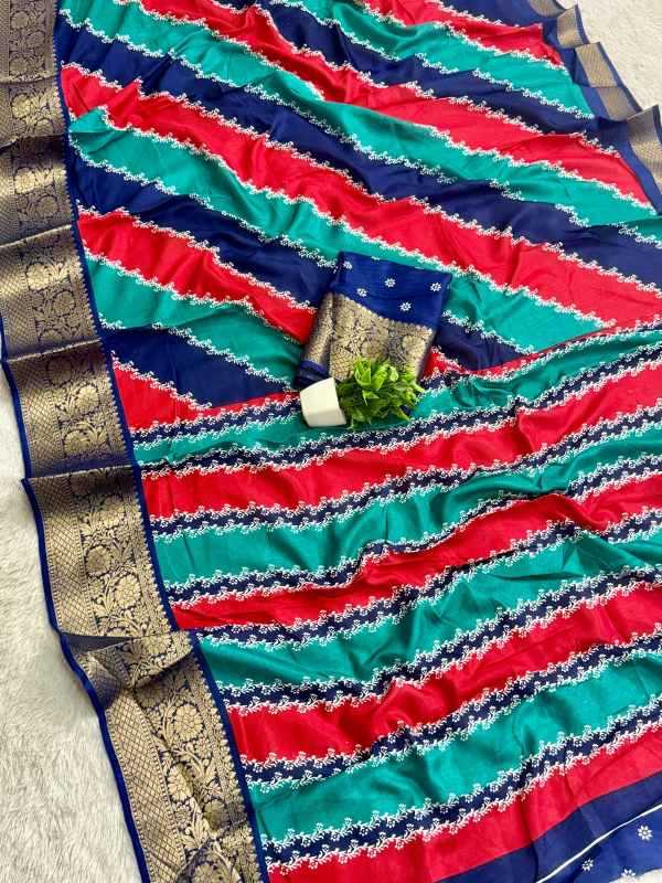 A striped silk saree with diagonal bands of red, teal green, and navy blue, featuring intricate white zari patterns and a wide gold brocade border. A matching navy blue fabric piece with gold embroidery is draped over the center, styled with a small green plant.