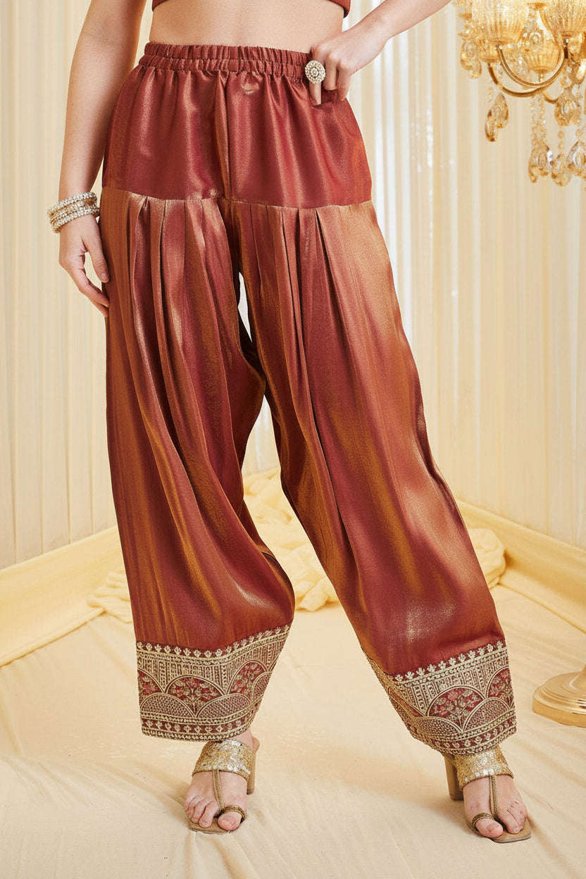 Brown traditional pants with intricate patterns on a decorative background