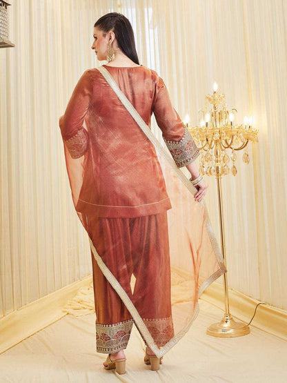 Woman in a traditional outfit standing in a room with a chandelier.