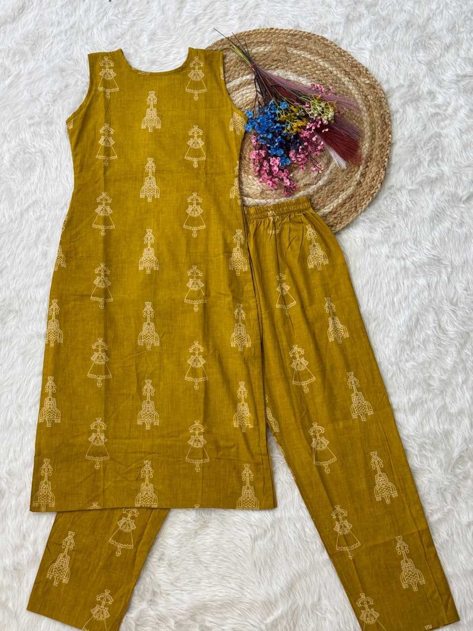 Mustard yellow traditional outfit with matching pants on a textured white surface.