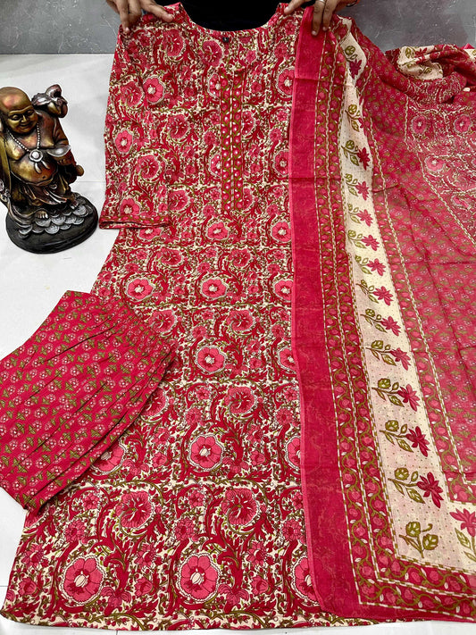 Red and gold patterned fabric with a statue in the background