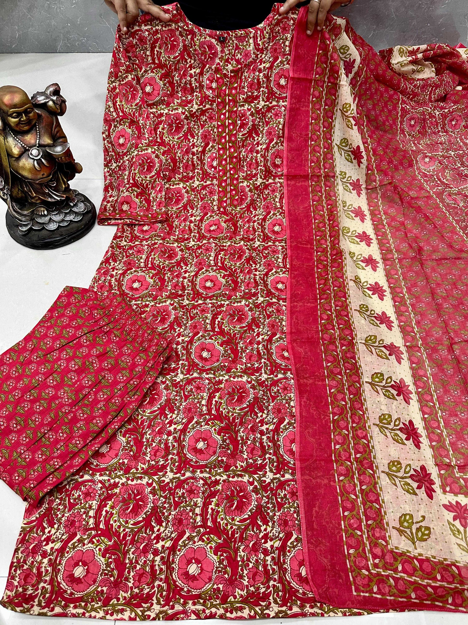 Red and gold patterned fabric with a statue in the background
