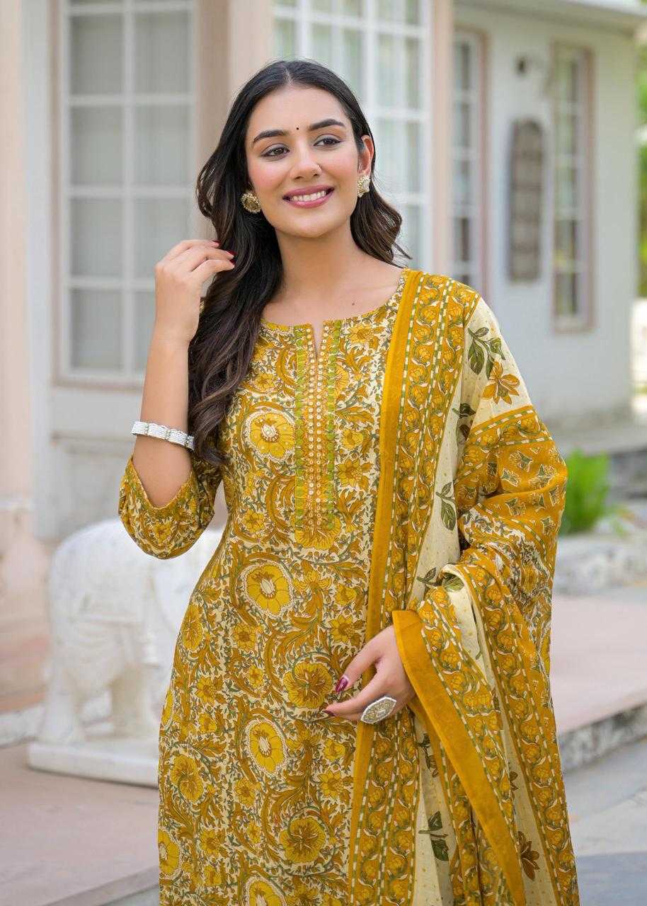 Woman wearing a yellow patterned outfit with a matching dupatta outdoors.