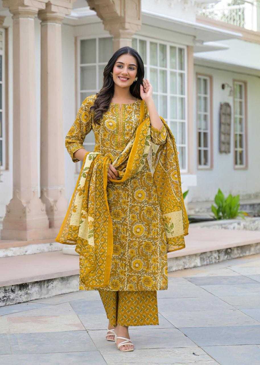 Woman in a yellow traditional outfit standing outdoors.