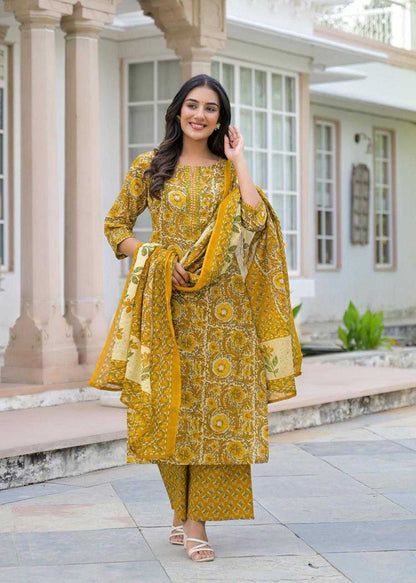 Woman in a yellow traditional outfit standing outdoors.