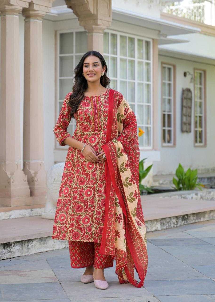Woman in a red and gold traditional outfit standing outdoors.